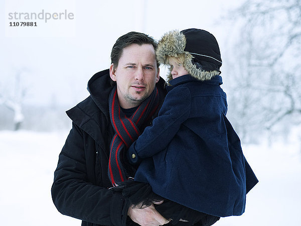 Porträt eines Vaters mit Tochter in einer Winterlandschaft