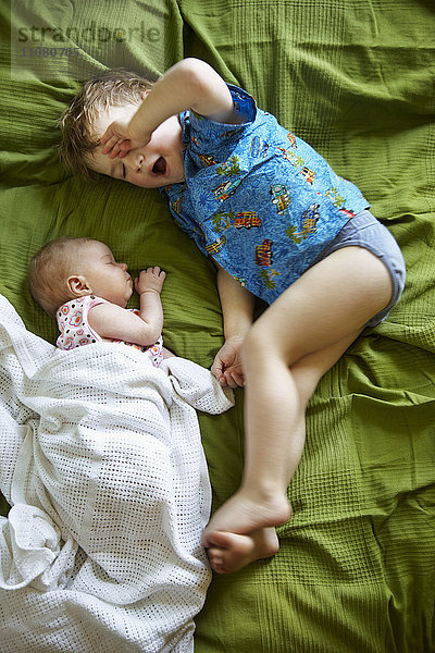 Junge und neugeborenes Baby auf dem Bett