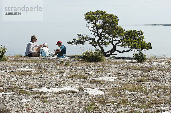 Familie entspannt sich auf dem Gipfel einer Klippe