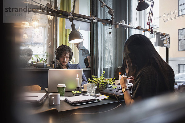 Blogger arbeiten im kreativen Büro durch Glas gesehen