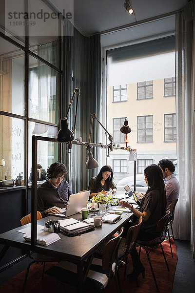 Kreatives Business-Team am Tisch bei der Arbeit im modernen Büro