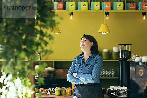 Lächelnde Besitzerin steht im Cafe