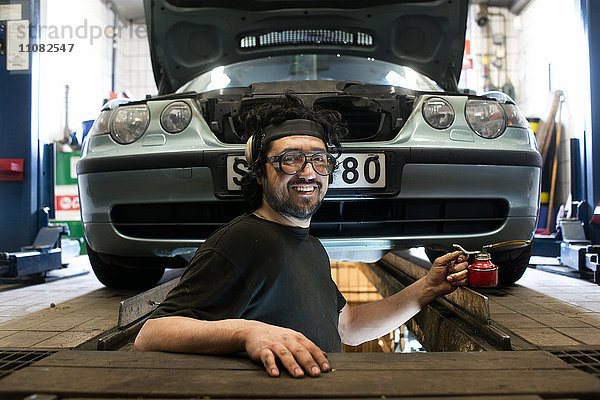 Lächelnder Mechaniker in einer Autowerkstatt