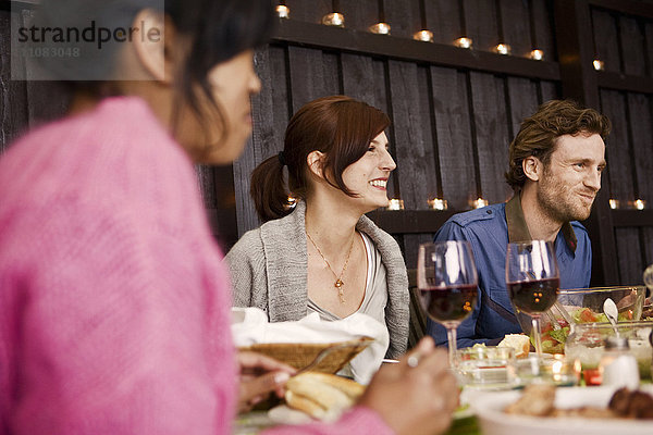 Lächelnde junge Leute auf einer Dinnerparty