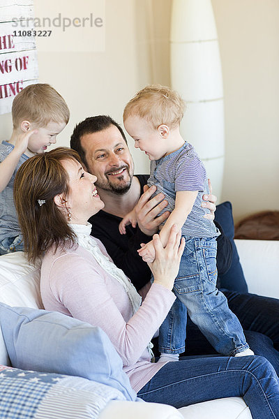 Familie mit zwei Kindern auf dem Sofa