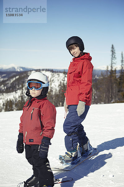Mutter mit Sohn beim Snowboarden