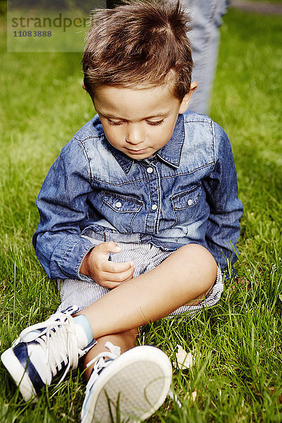 Junge sitzt im Gras  Stockholm  Schweden