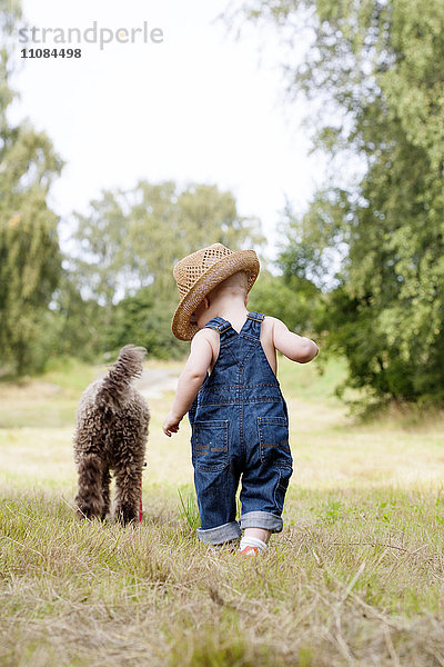 Kleinkind beim Spaziergang mit Hund