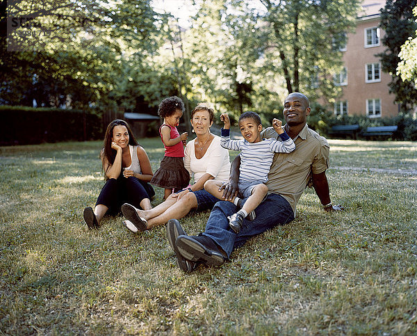 Familie auf dem Rasen sitzend