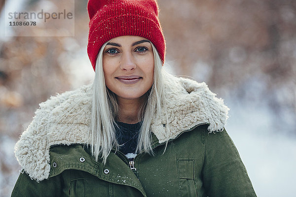 Porträt einer selbstbewussten jungen Frau  die im Winter im Freien steht.