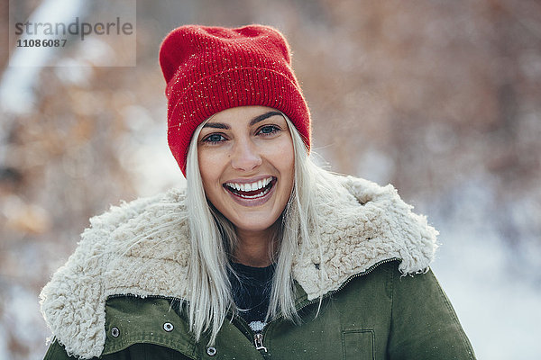 Porträt einer glücklichen jungen Frau  die im Winter im Freien steht.