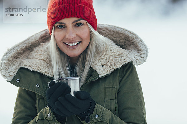 Porträt einer jungen Frau beim Kaffee im Winter