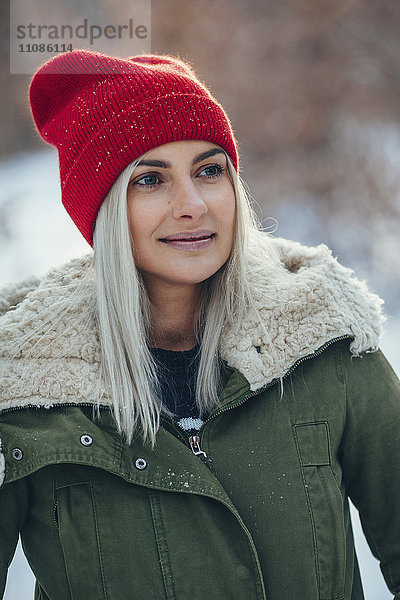 Nahaufnahme einer jungen Frau  die im Winter wegguckt.