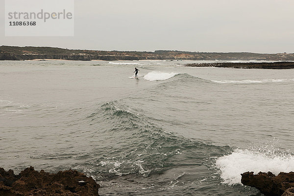 Person beim Surfen am Strand  Vila Nova de Milfontes  Portugal