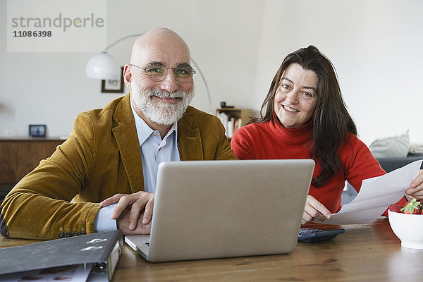 Porträt eines reifen Paares mit Laptop zu Hause