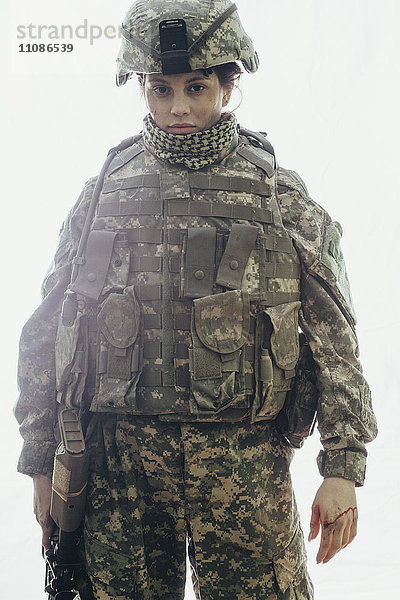 Porträt eines Soldaten mit Gewehr vor weißem Hintergrund