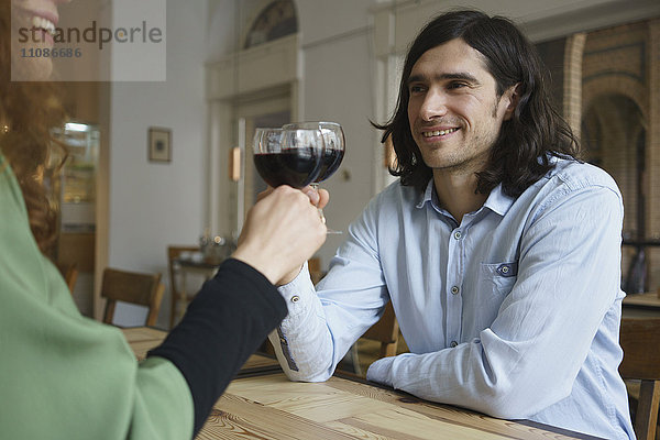 Freunde stoßen im Café auf Wein an.