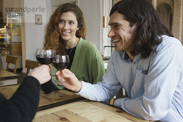 Fröhliche Freunde beim Weintrinken im Cafe