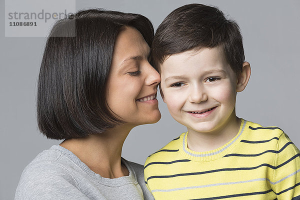 Nahaufnahme der liebenden Mutter mit Sohn vor grauem Hintergrund
