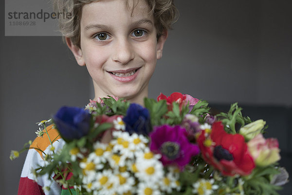 Nahaufnahme des lächelnden Jungen mit Blumenstrauß