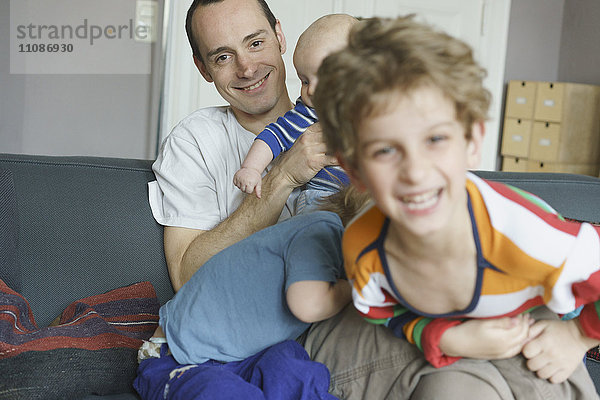 Glückliche Familie beim Spielen auf dem Sofa zu Hause