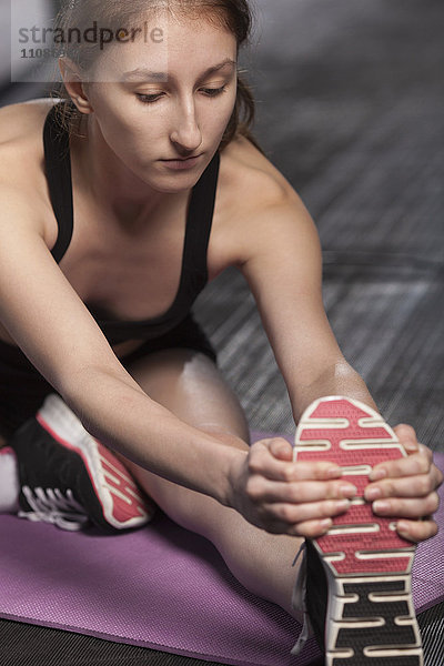 Teenagermädchen beim Stretching im Fitnessstudio