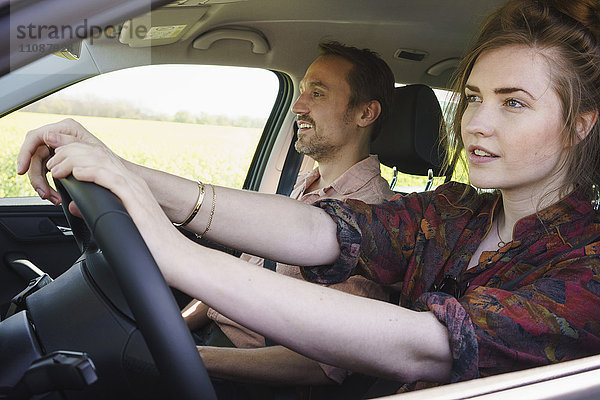 Frau beim Fahren neben Mann im Auto sitzend
