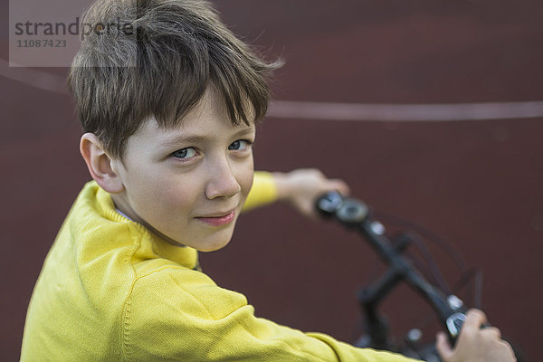 Porträt des lächelnden Jungen beim Radfahren im Freien