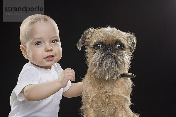 Portrait des Jungen mit Hund auf schwarzem Hintergrund