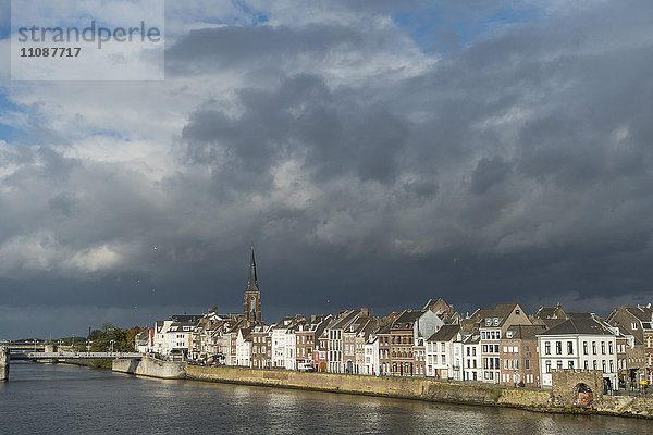 Maas bei Häusern in der Stadt gegen bewölkten Himmel