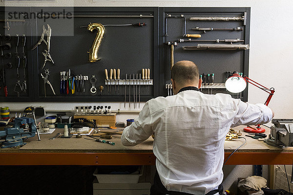 Instrumentenbauer in seiner Werkstatt