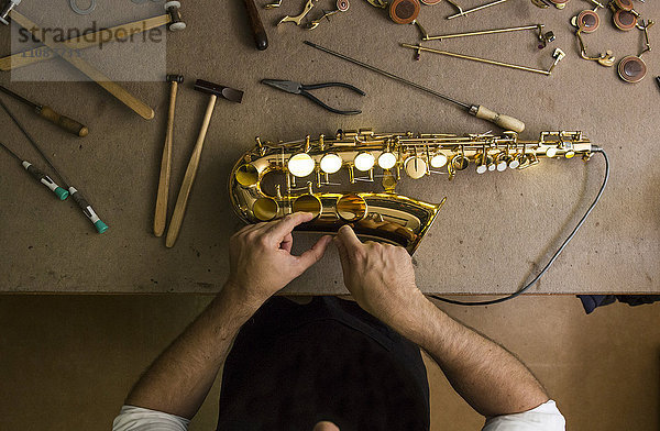 Instrumentenbauer bei der Reparatur eines Saxophons