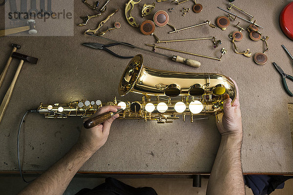 Instrumentenbauer bei der Reparatur eines Saxophons