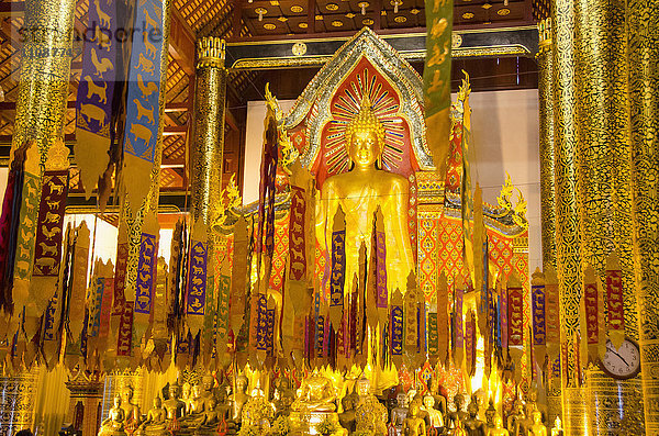 Gebetsfahnen gegen Buddha-Statuen im Wat Chedi Luang Tempel