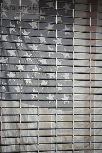 Vollbildaufnahme der amerikanischen Flagge hinter dem Metallfenster