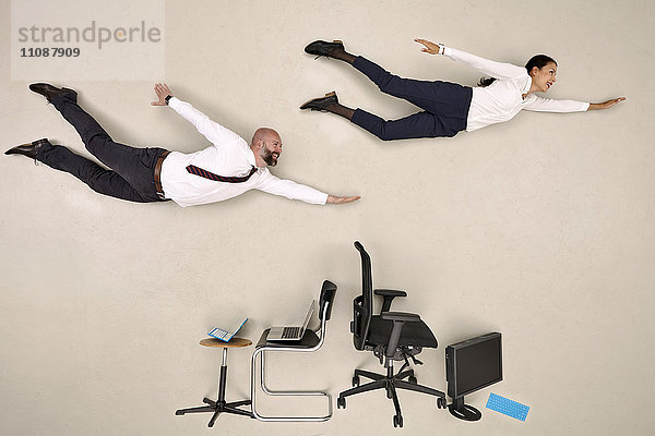 Geschäftskollegen  die über Stühle und Geräte fliegen
