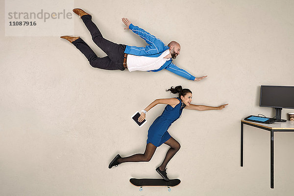 Moderne Geschäftskollegen fliegen und skateboarden in Richtung Bürotisch