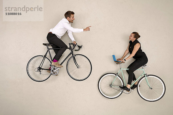 Zwei Geschäftskollegen beim Radfahren und Kommunizieren