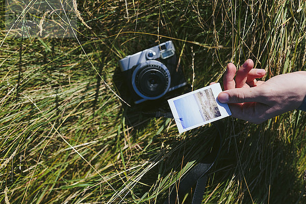 Männerhand mit Polaroid