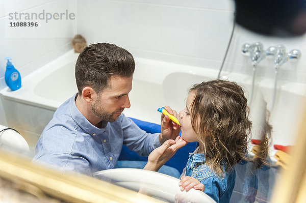 Vater putzt Mädchenzähne