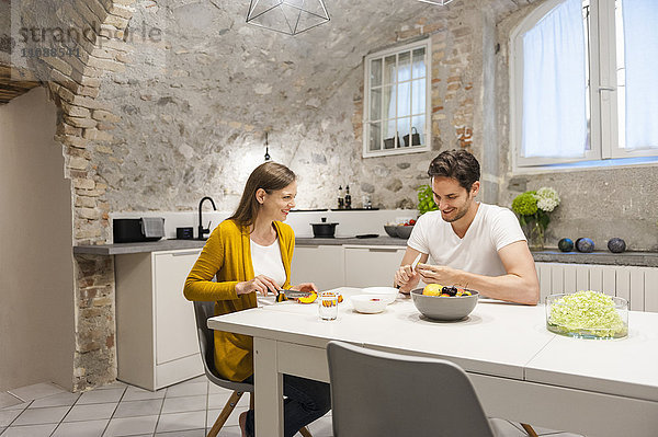 Paar in der Küche bei der Zubereitung von Obstsalat