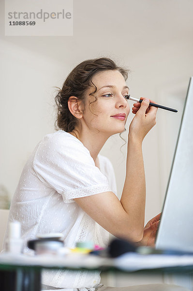 Frau zu Hause mit Augen-Make-up