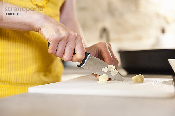 Frau in der Küche schneidet Pfirsich