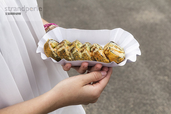 Hände des Teenagermädchens halten Schale Sushi mit Garnelen