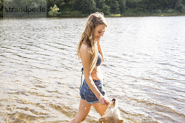 Junge Frau mit ihrem Hund im See