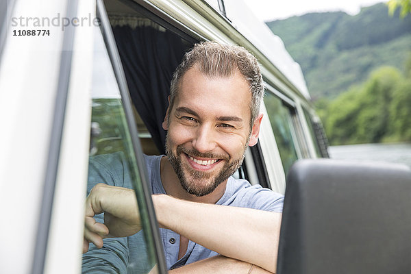 Porträt eines lächelnden Mannes im Van