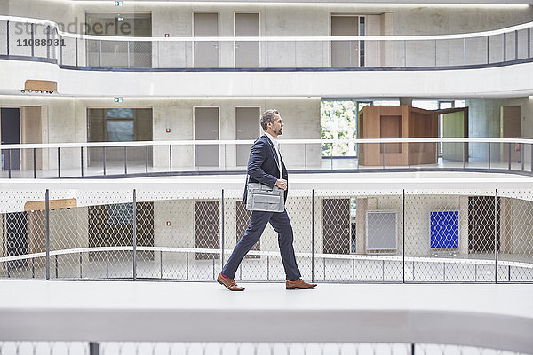 Geschäftsmann zu Fuß mit Tasche im modernen Bürogebäude