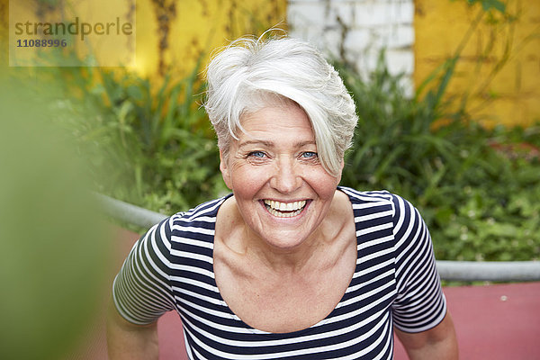 Porträt einer glücklichen Frau im Garten