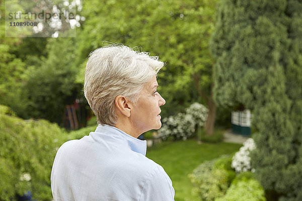 Profil der Frau mit grauem Haar im Garten