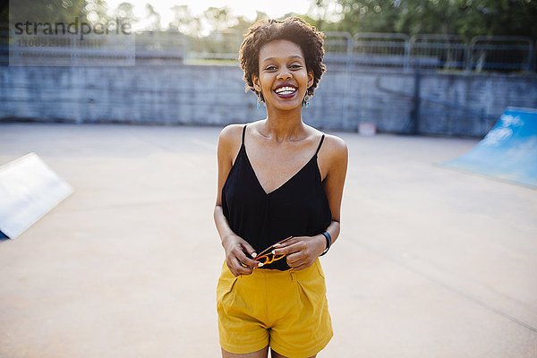 Porträt einer lächelnden jungen Frau im Skatepark